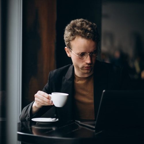 handsome-man-working-computer-cafe-drinking-coffee-min.jpg